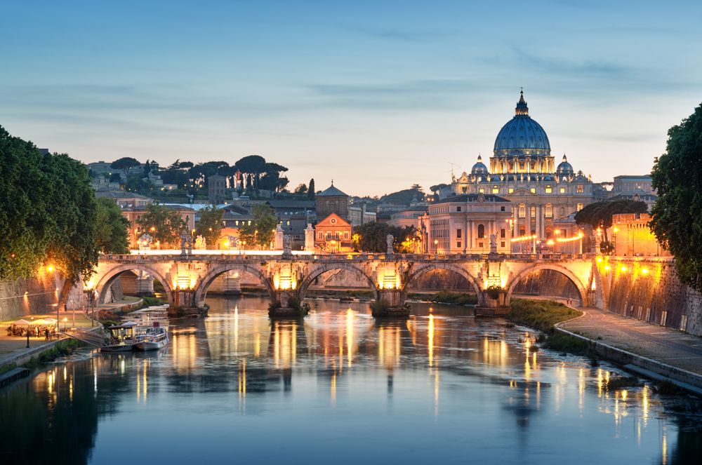 St. Peter’s Basilica and the Tiber River at dusk in Rome, Italy.