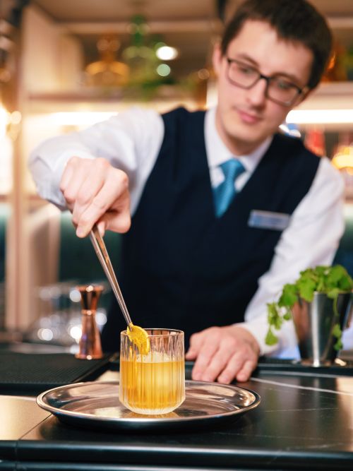 Bartender preparing a handcrafted cocktail onboard