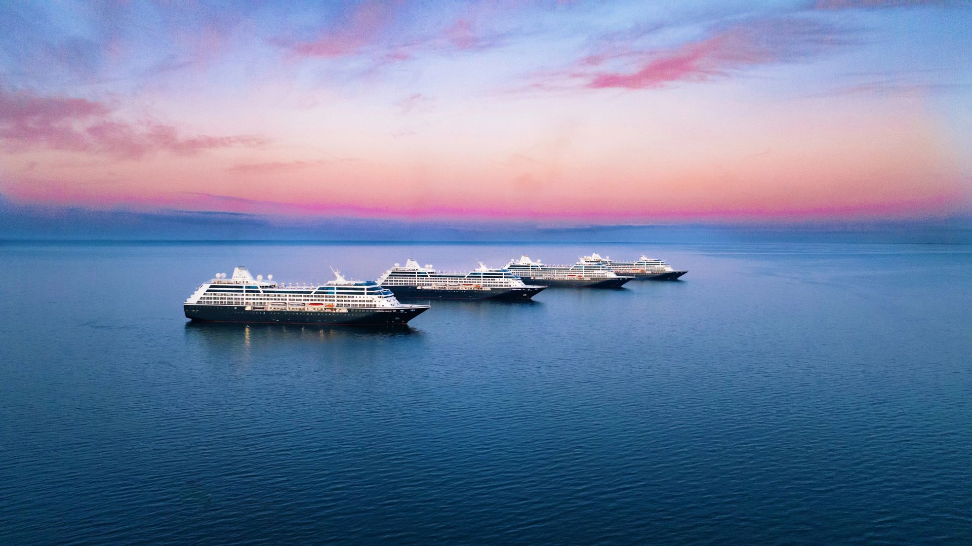 sister cruise ships at sea at dusk