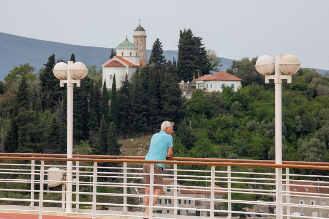 Guest viewing a church from a cruise ship deck
