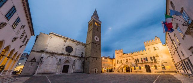 Koper's Cathedral bell tower and Praetorian Palace illuminated at dusk on Tito Square