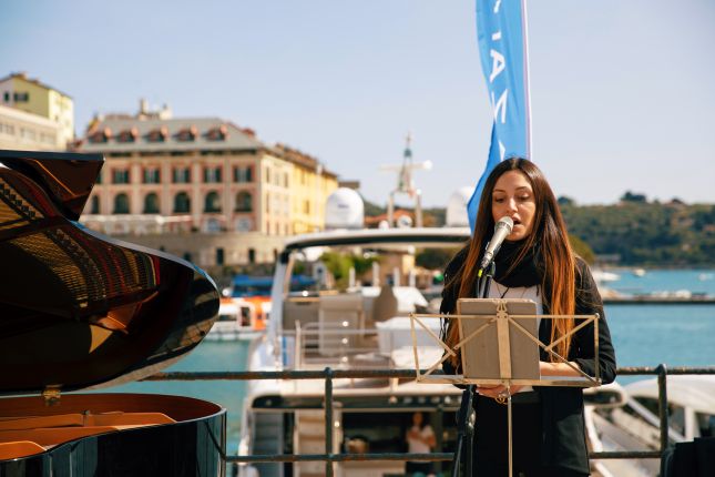 Singer performing beside a piano in Portovenere