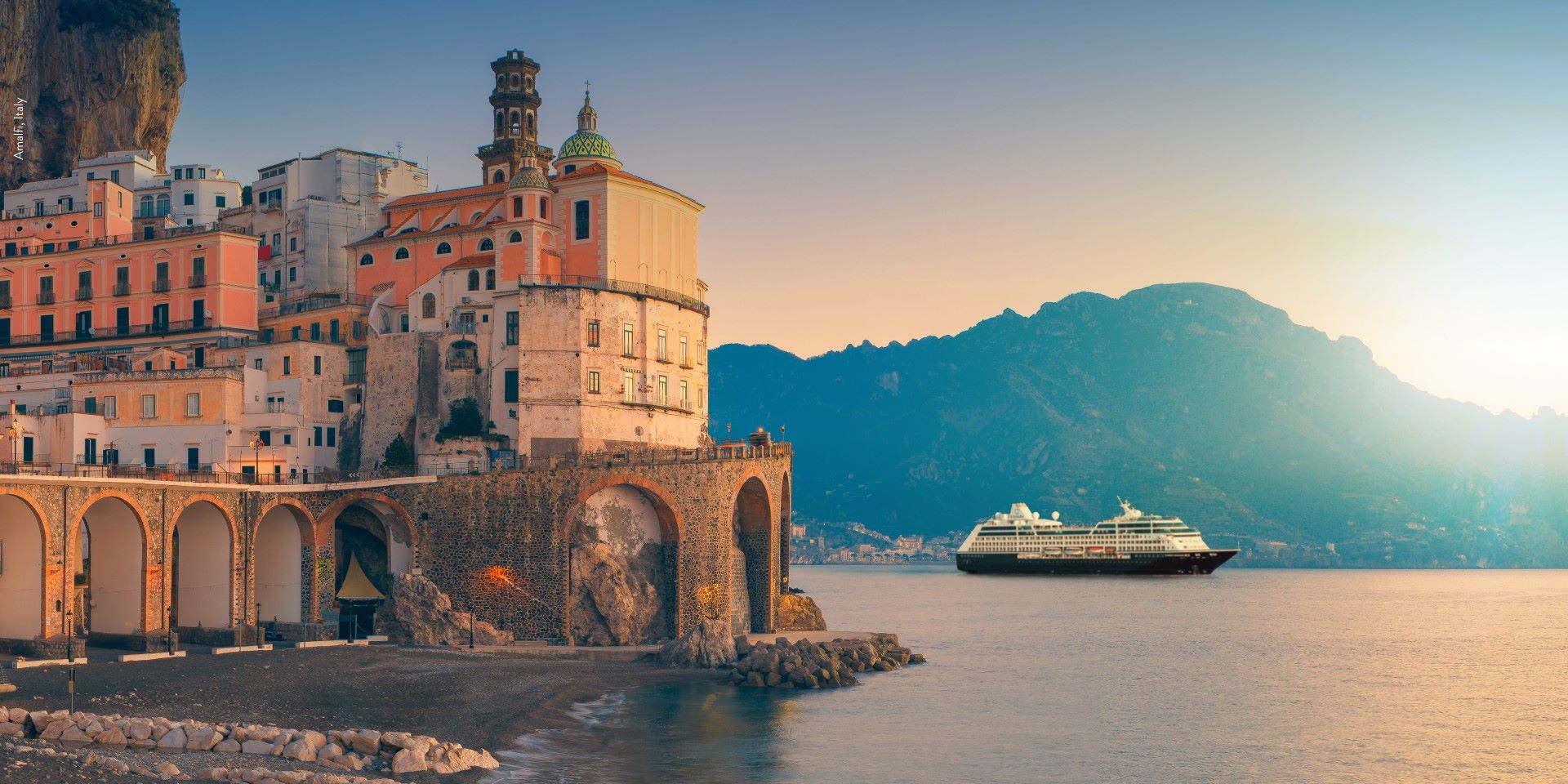 cruise ship sailing into port as sun sets behind 