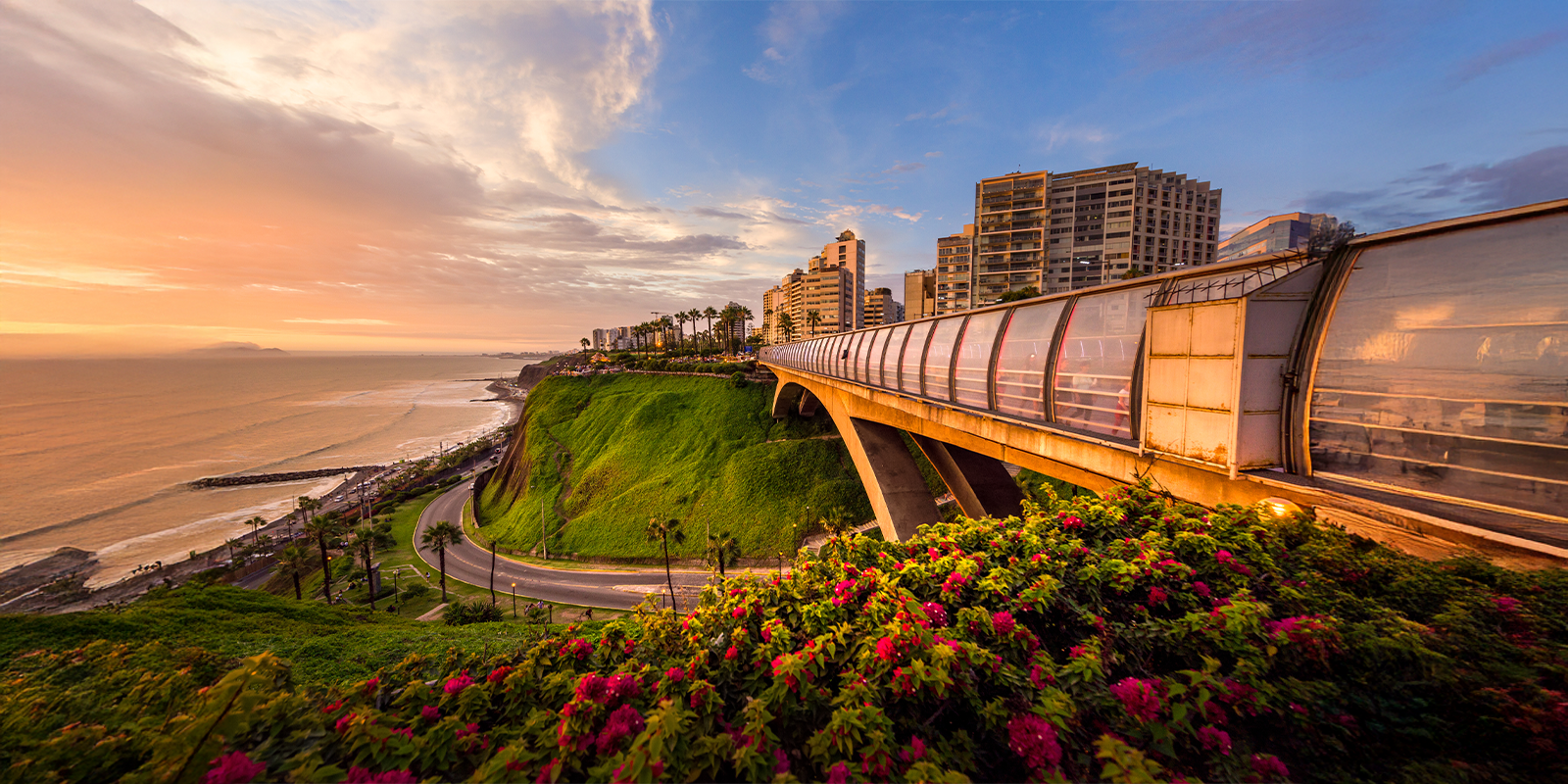 Lima, Peru’s Miraflores coastline at sunset with cliffs, ocean views, and the iconic bridge.