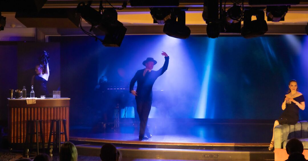 ships captain taking a selfie from stage with large audience in background