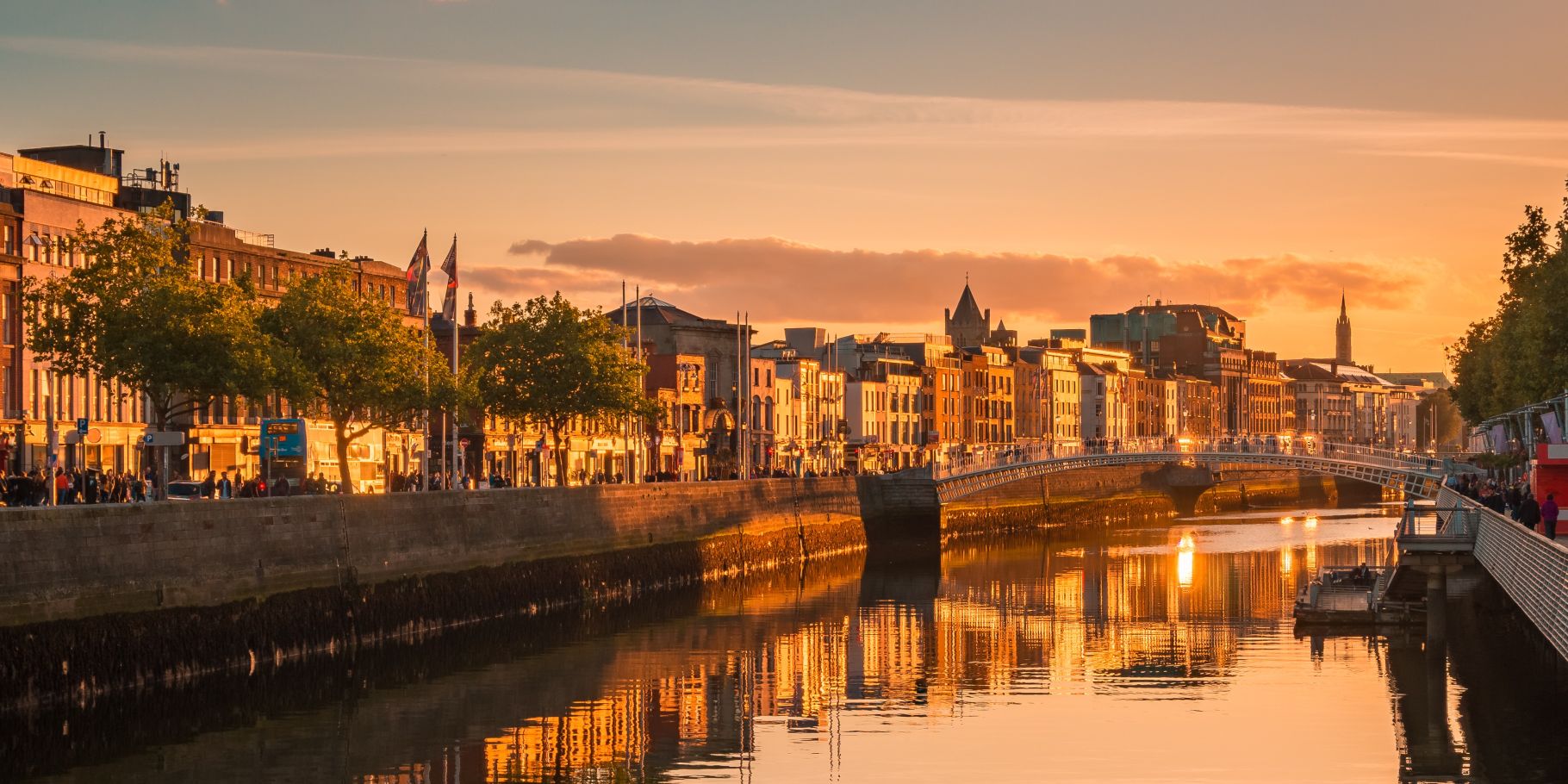 Dublin’s riverfront and Ha’penny Bridge at sunset.