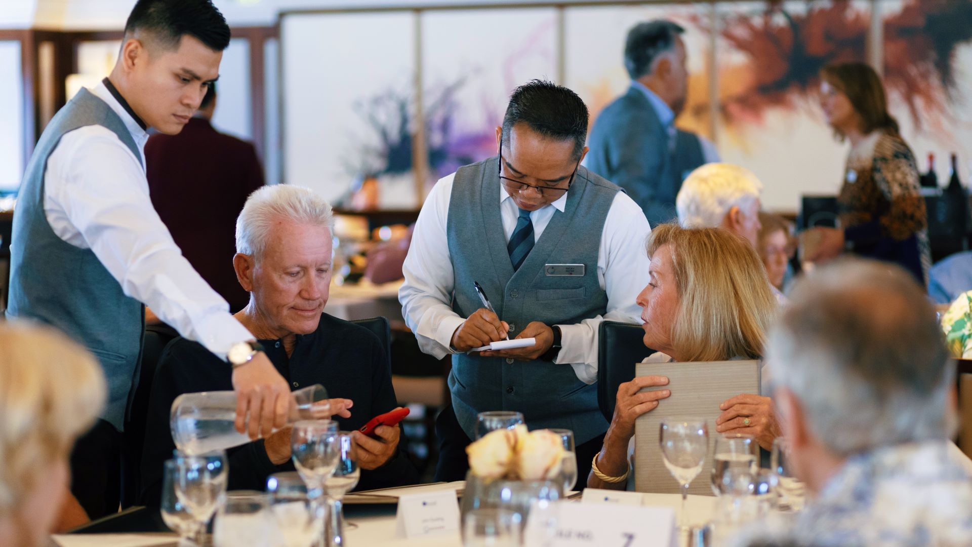 couple enjoying dinner in dining room speaking to waiter