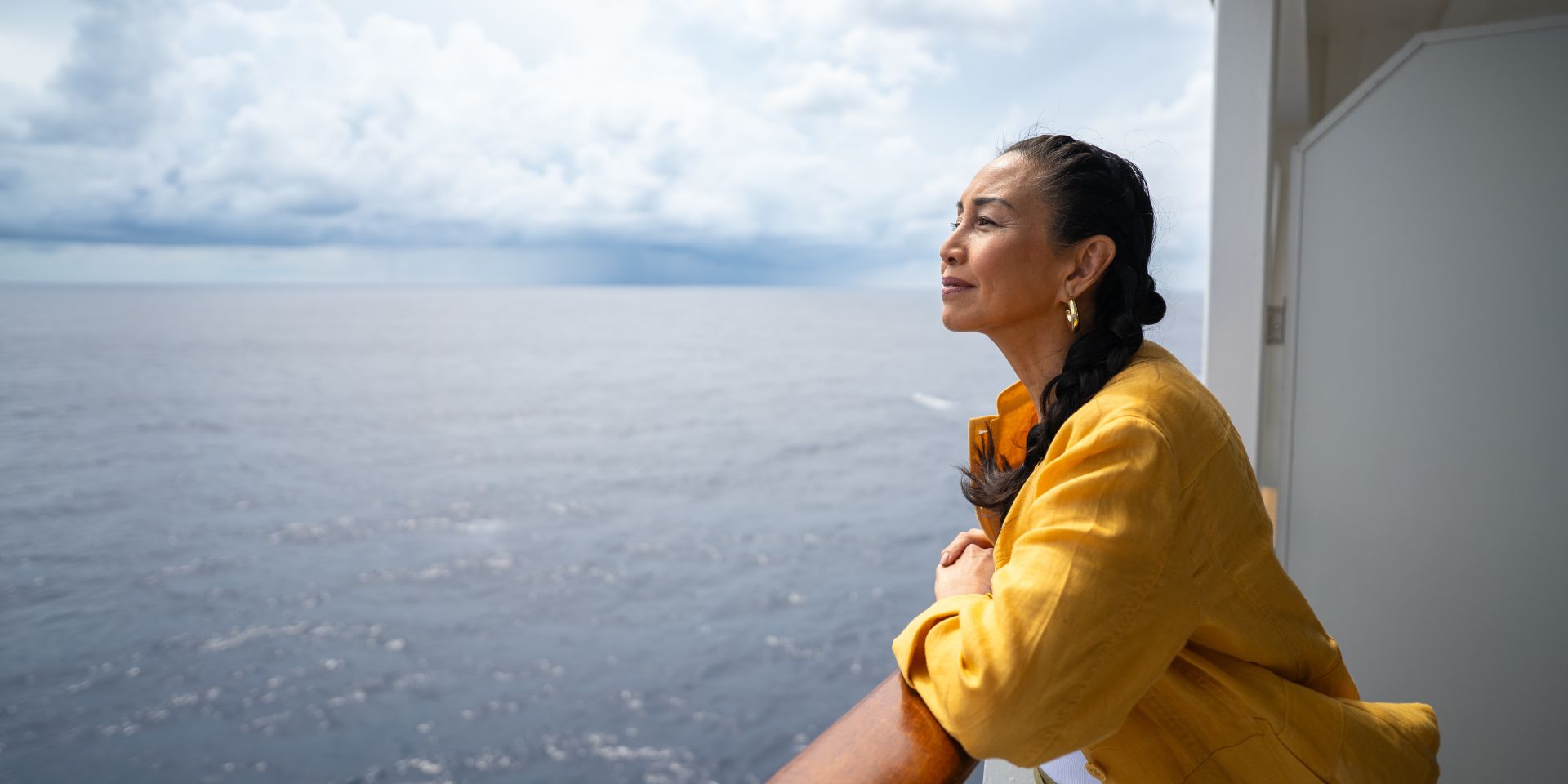 Woman gazing out at the ocean from a cruise ship