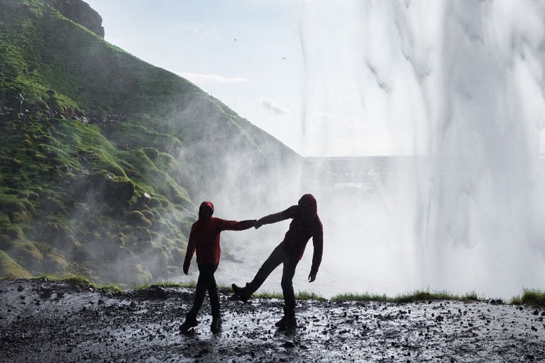 Couple dancing under waterfull in Iceland