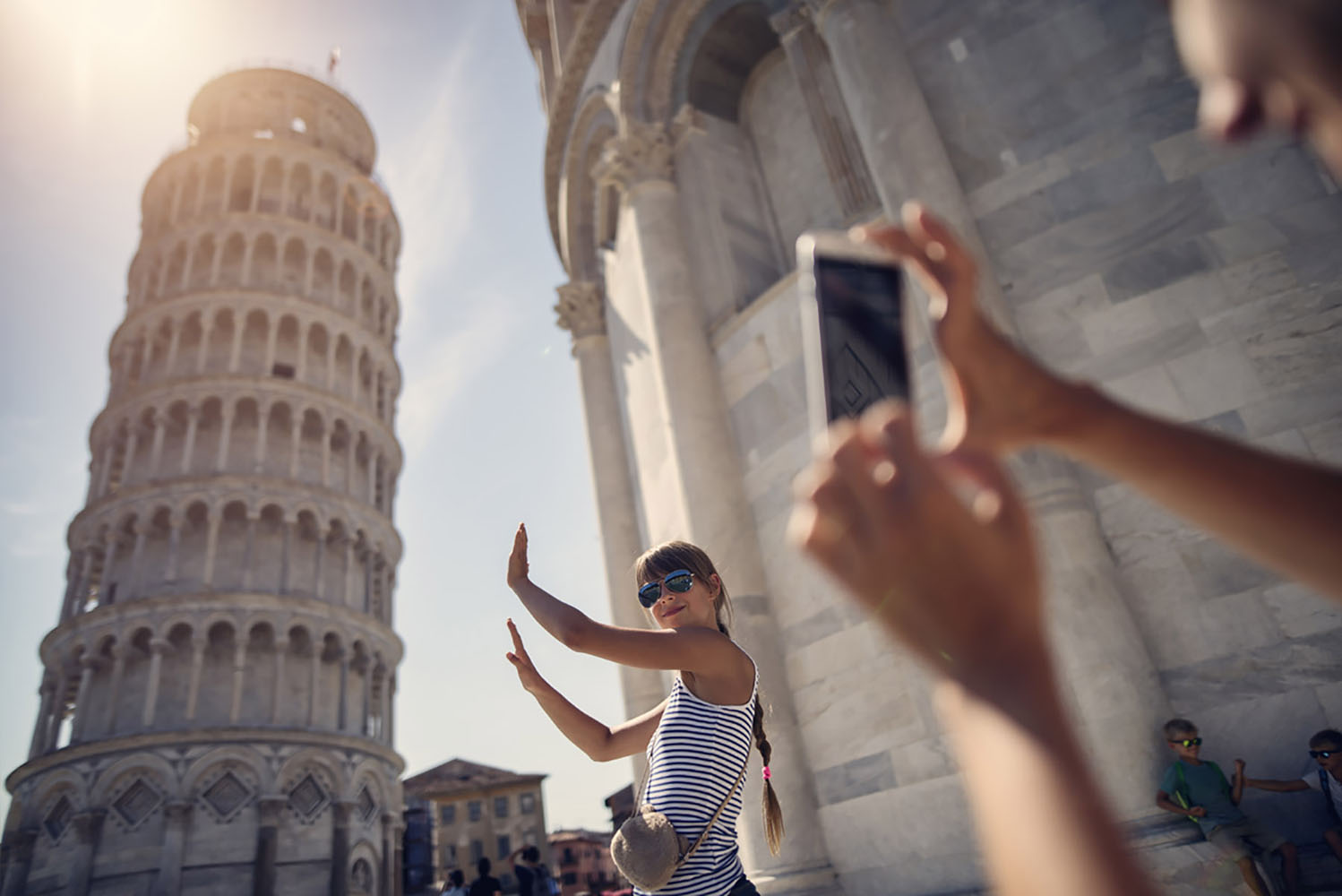 A lady recreates an iconic photo op near the Tower of Pisa