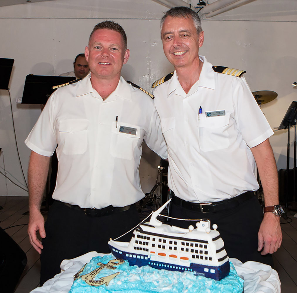 Captain Carl poses with Hotel Director Phillip and the cake.