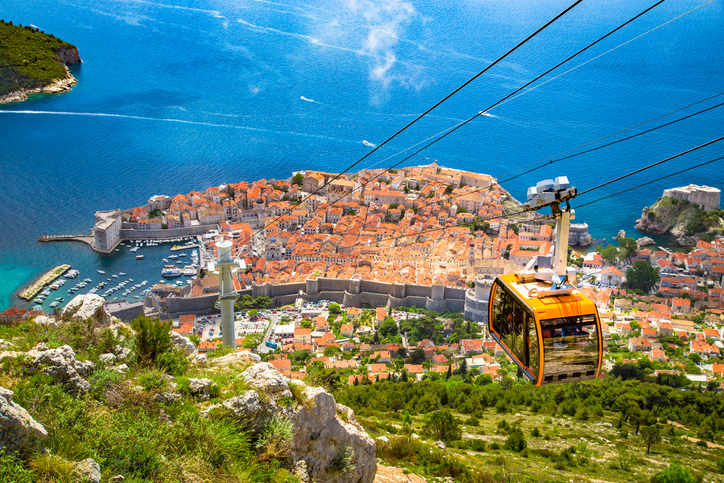Old town of Dubrovnik with cable car ascending Srd mountain