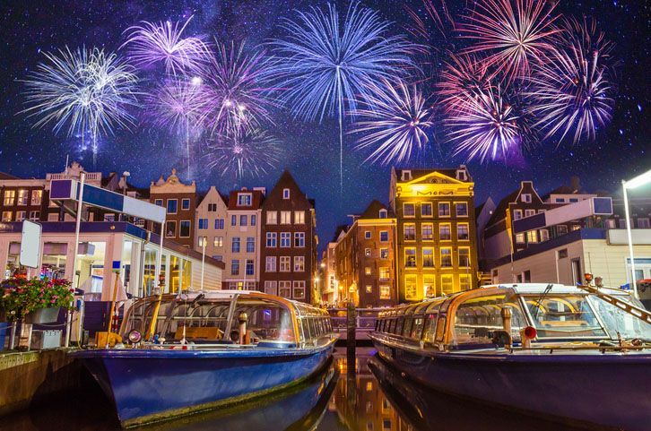 Traditional old buildings and boats with fireworks in Amsterdam