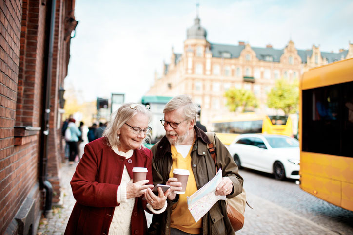 A senior couple on a vacation using their phone