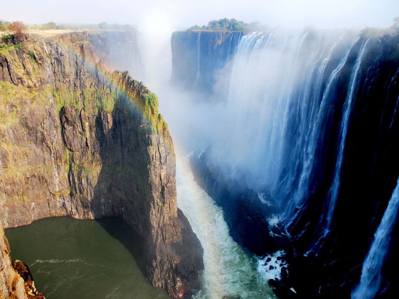 An aerial shot of Victoria Falls waterfalls, with a rainbow.