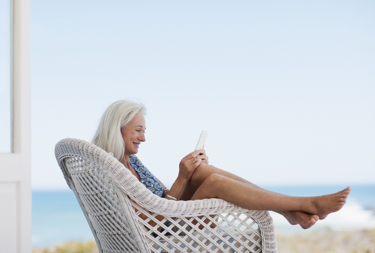 Senior woman using digital tablet in chair