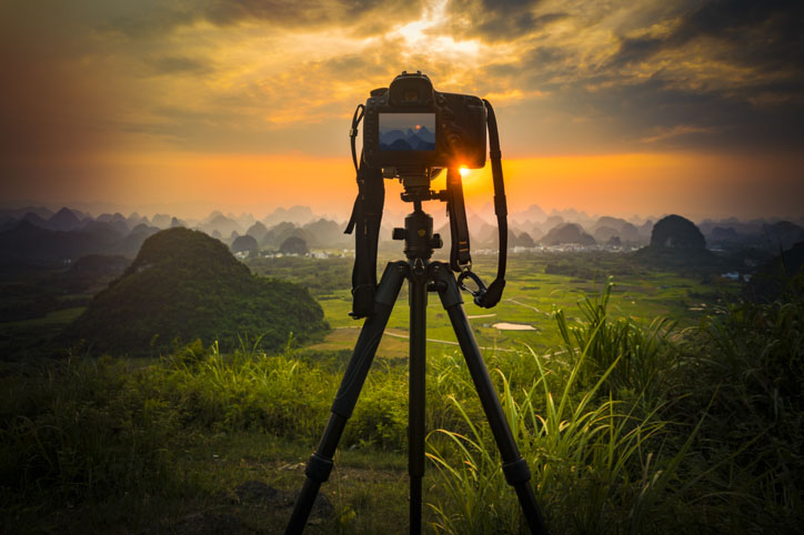 DSLR Camera on tripod taking a photo of the sunset