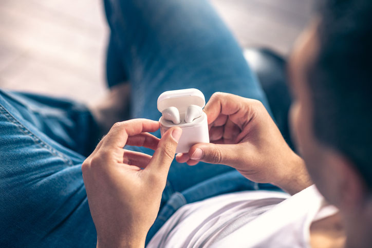 A man holding Apple AirPods