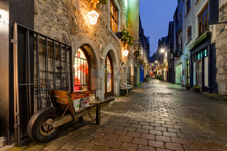 lights decorate an old street in Galway, Ireland in the evening