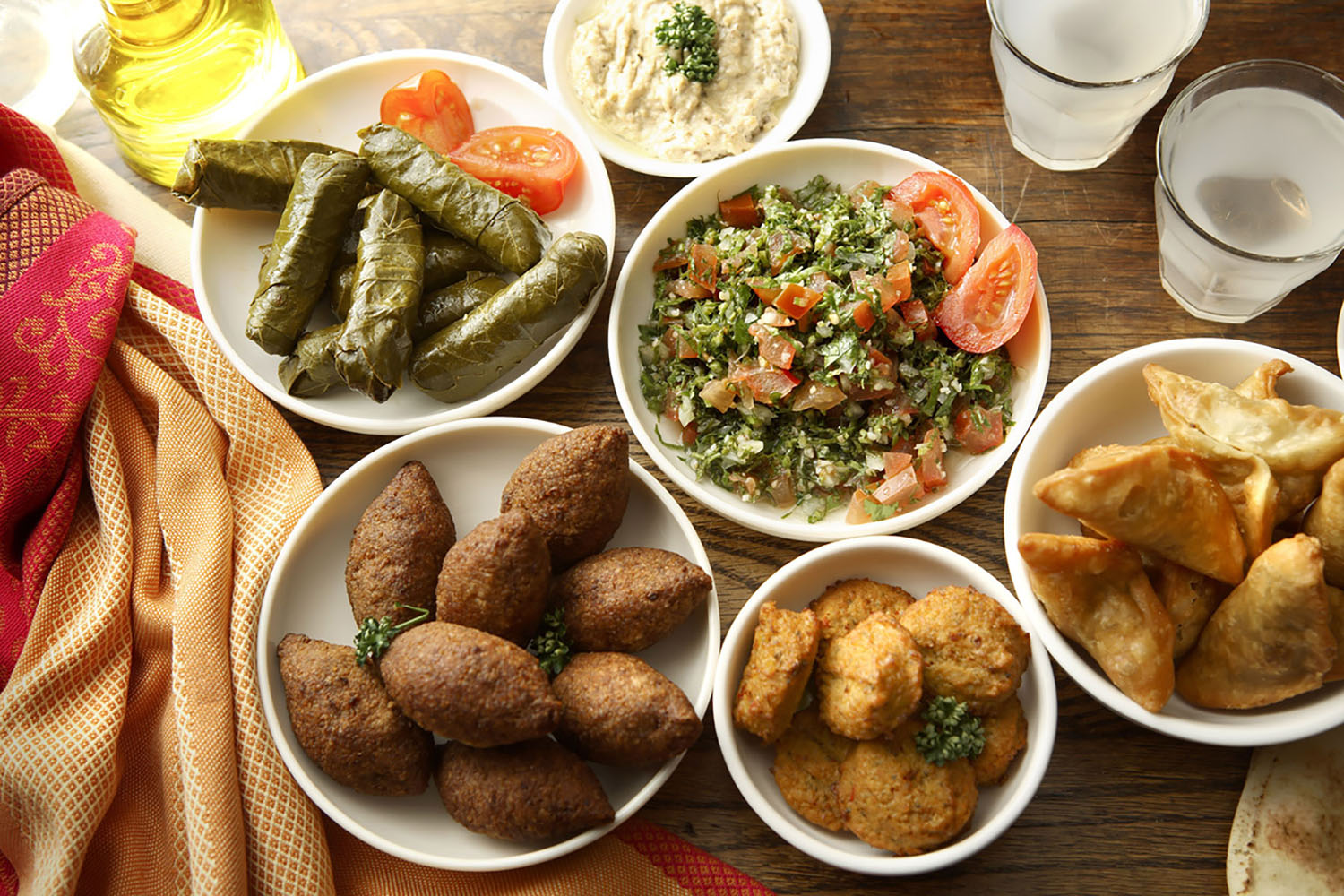 Mediterranean mezzes, including grape leaf rolls and falafel.