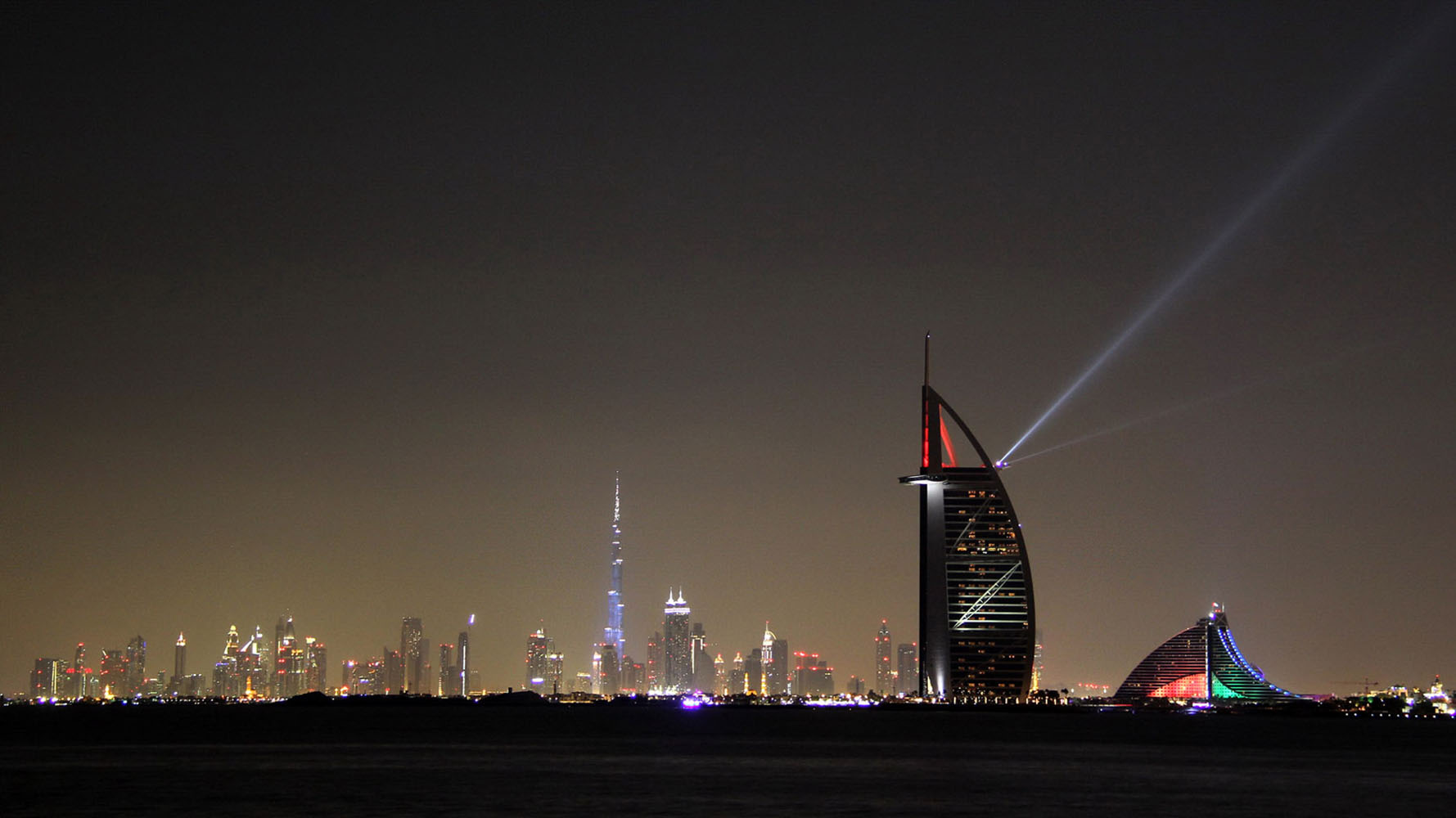 The Burj al Arab lit up with colorful lights on a Dubai evening