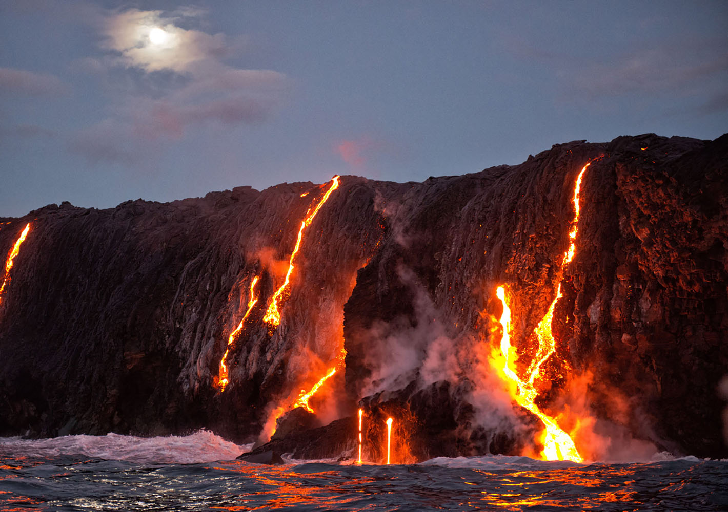 Lava flows into the water on an evening in Hawaii
