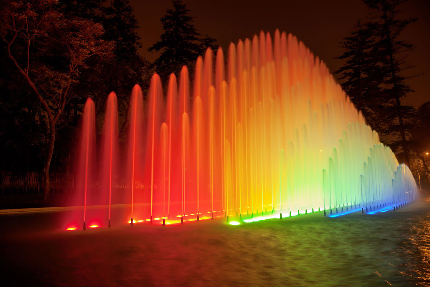 Colorful rainbow fountain at night in Park of the Reserve, Lima, Peru