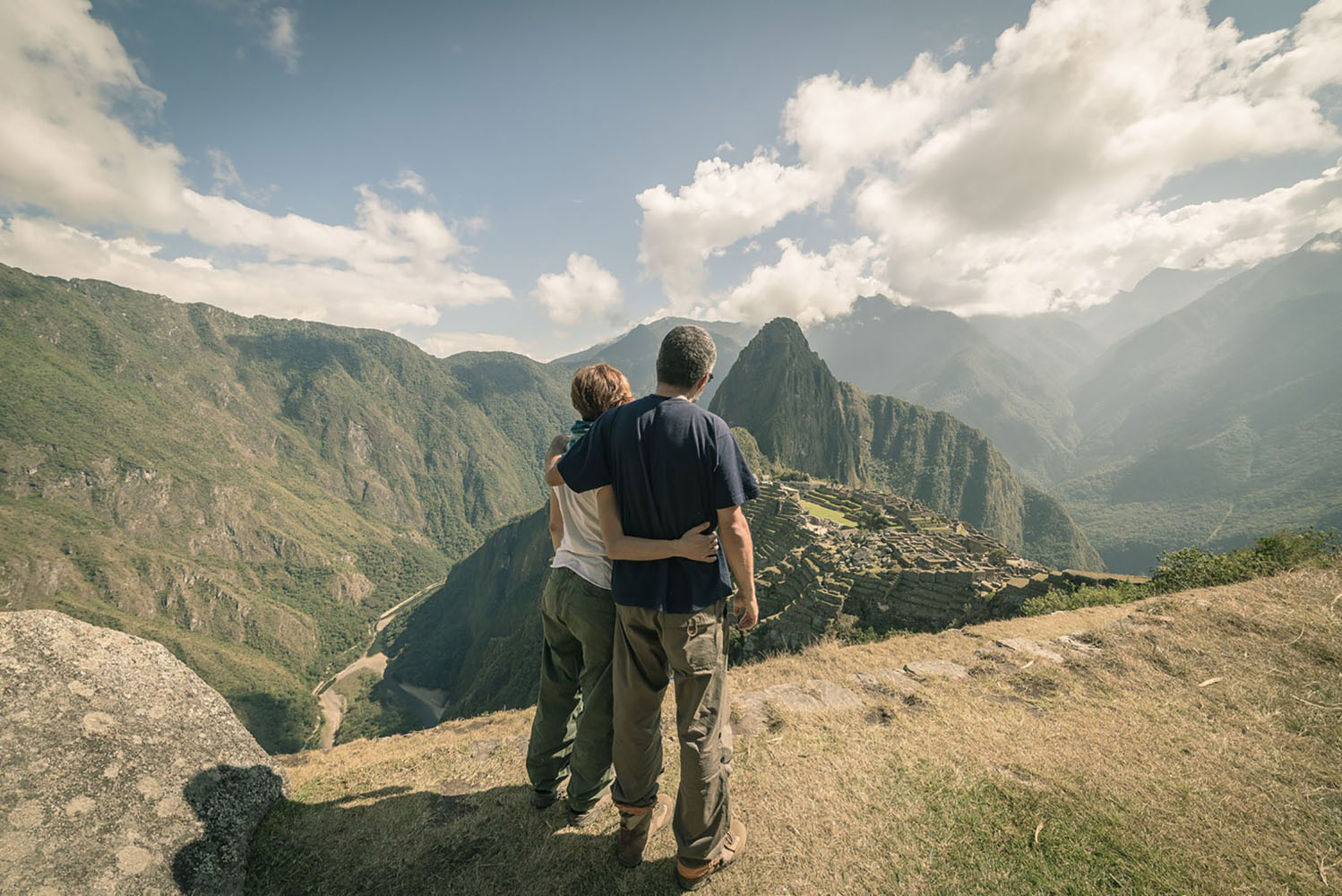 Hugging couple looking at Machu Picchu