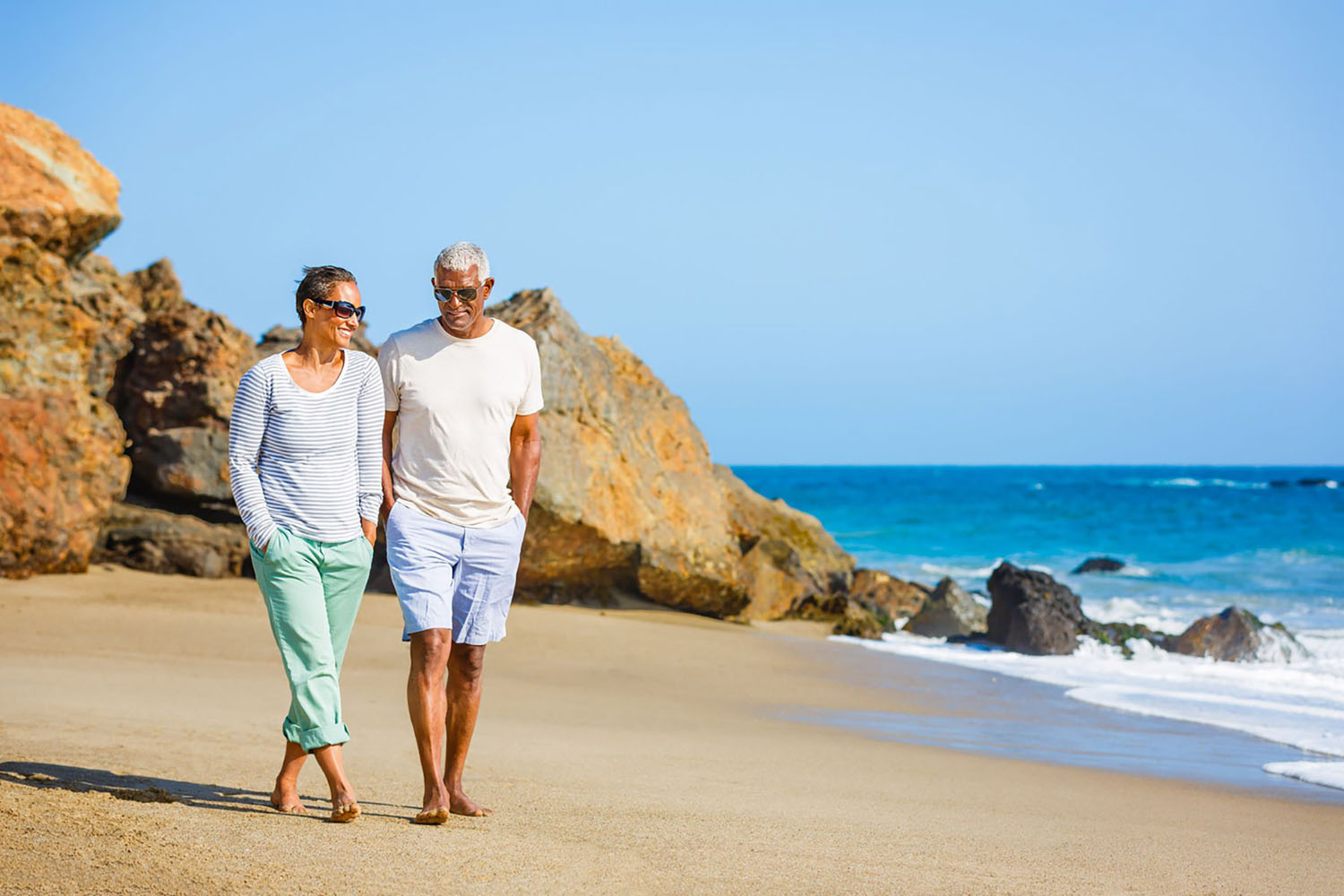 African American couple walking on beach