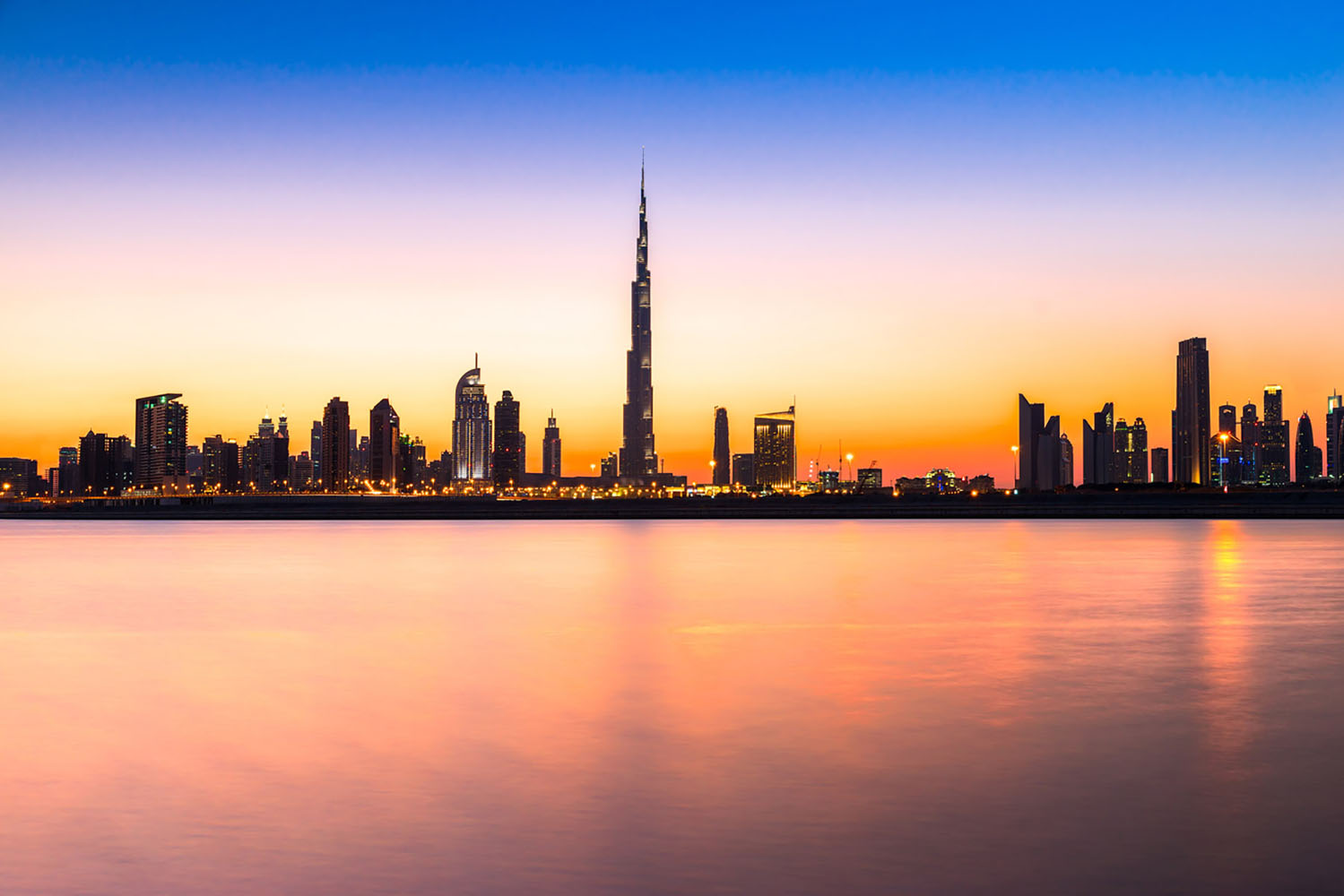 A silhouette of the The Burj Khalifa and Dubai skyline at sunset
