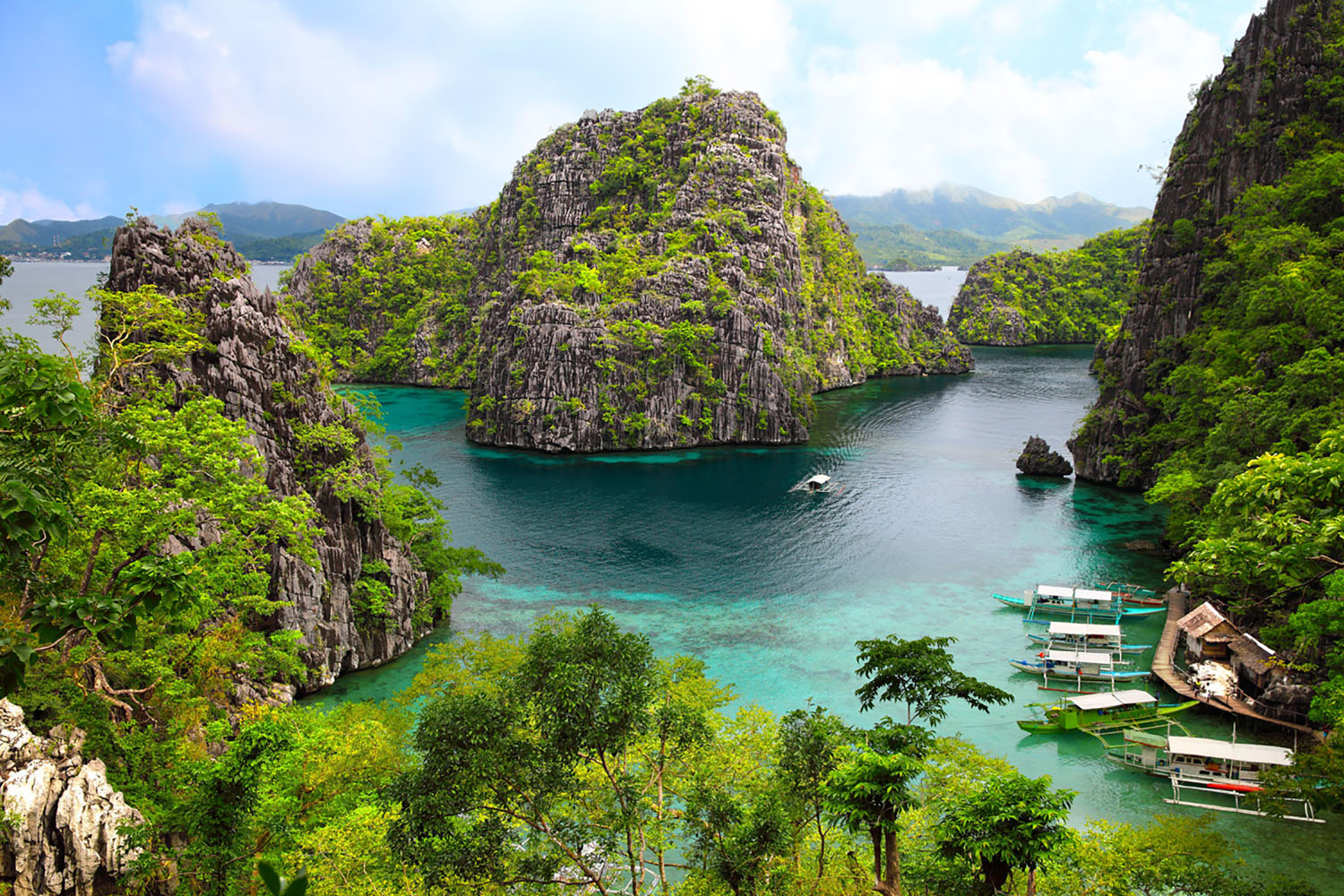 A blue lagoon surrounded by towering cliffs in Coron, Philippines