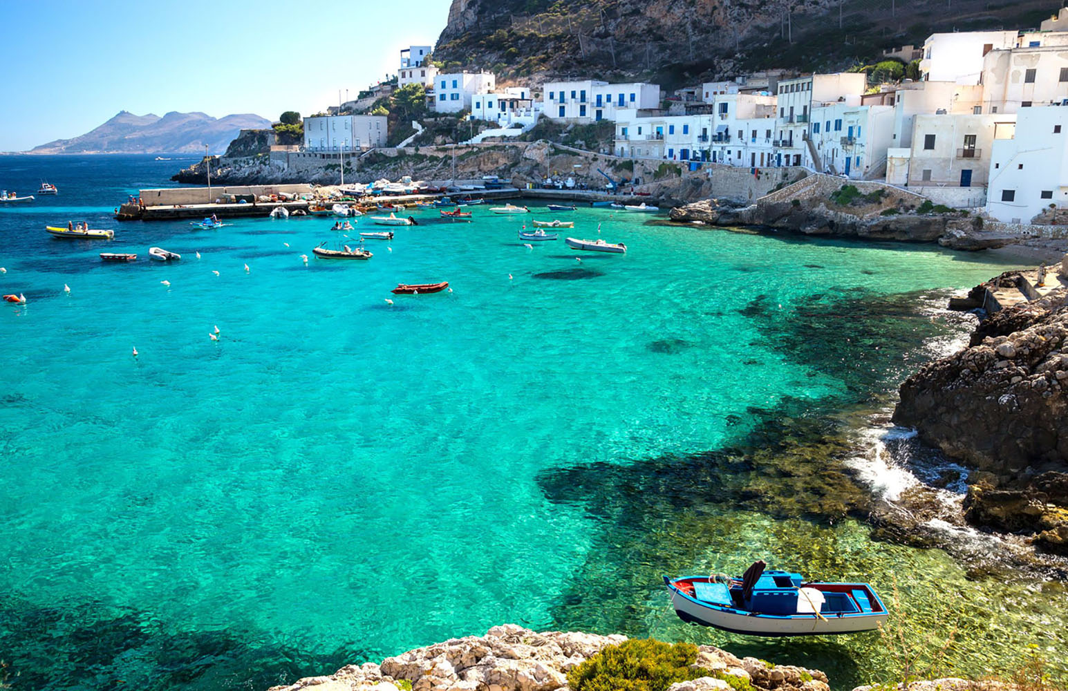 Levanzo Island with boats in the harbor.