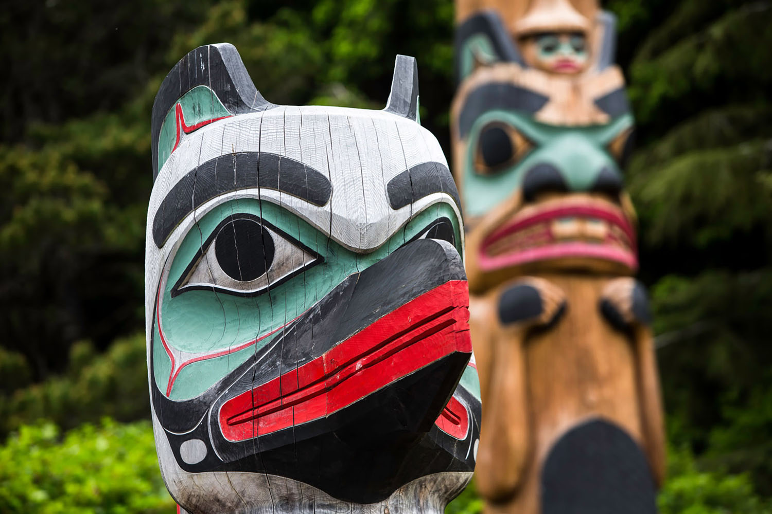 Totem Guard at Saxman Village with Beaver pole in background