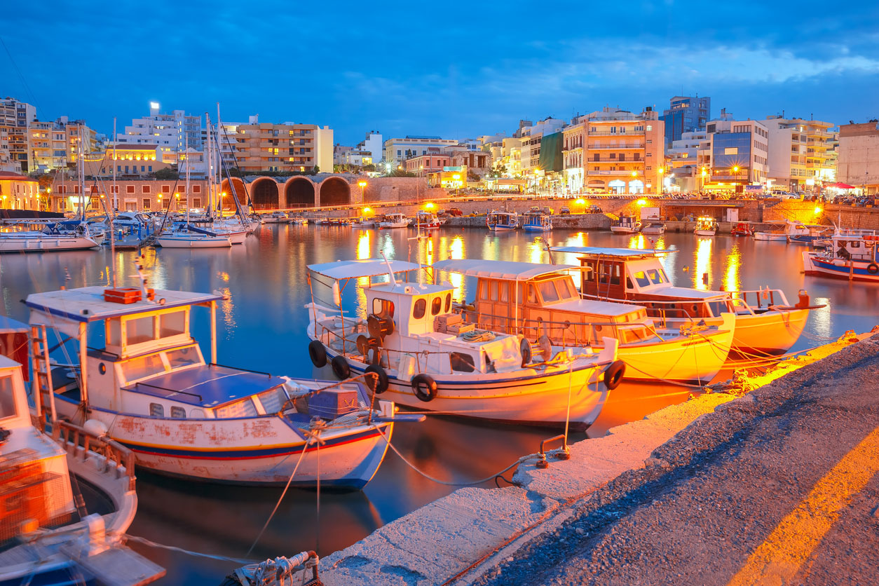Old harbour of Heraklion with fishing boats and marina during twilight blue hour, Crete, Greece