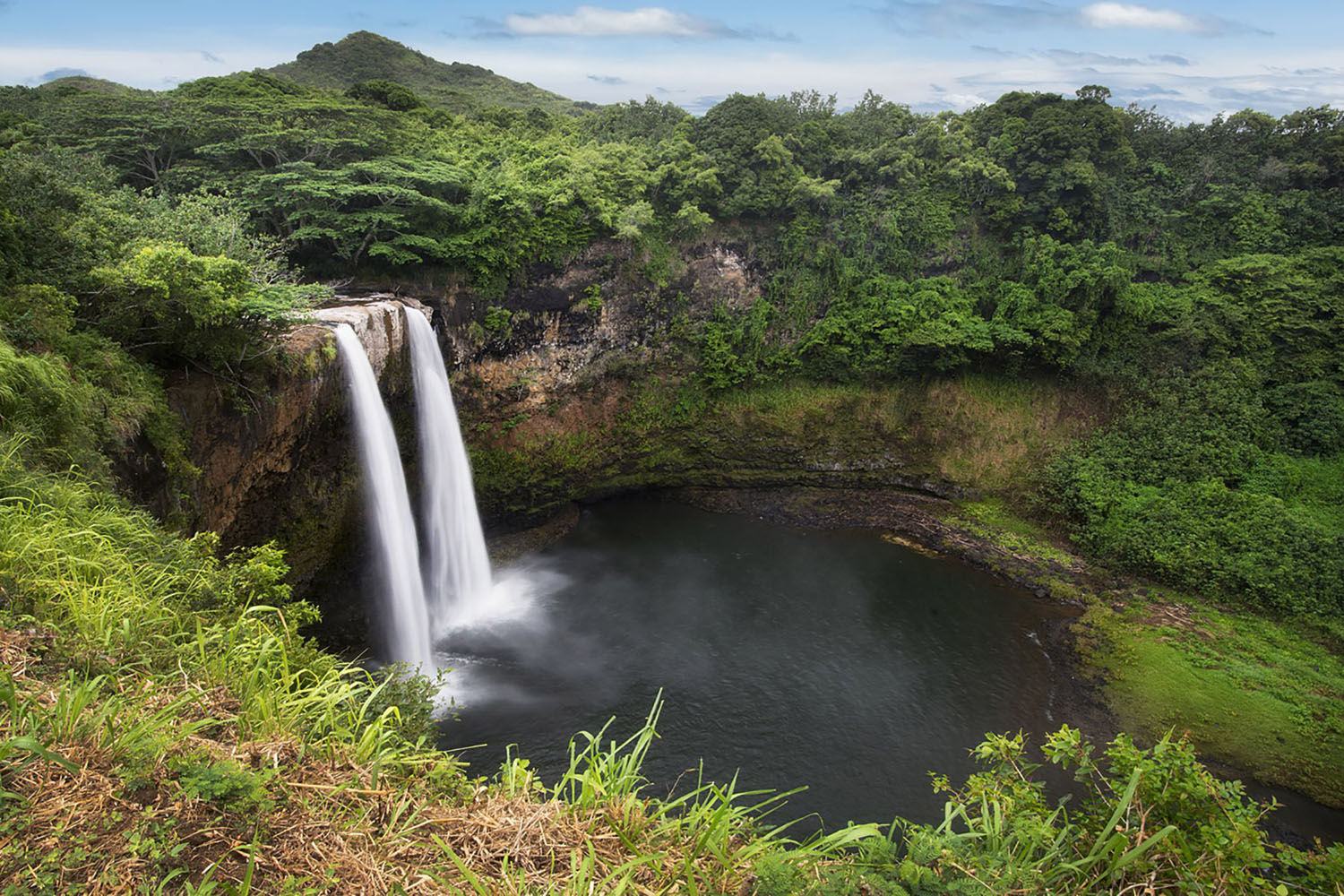 The Wailua Falls surrounded by lush green vegetation in Hawaii