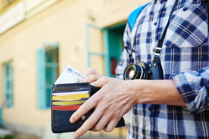 A man opens his travel wallet while on vacation
