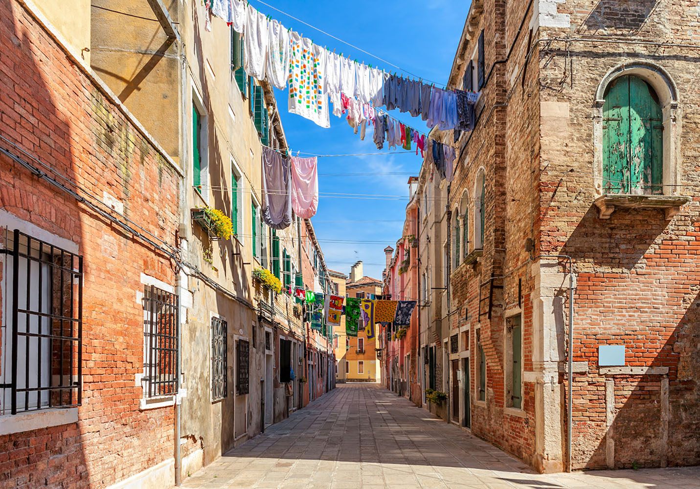 Laundry hangs from homes on a quiet street in Venice, Italy.