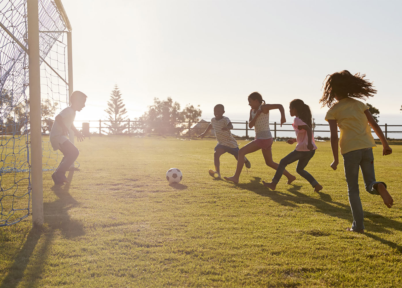 Children play soccer as the sun sets in South Africa