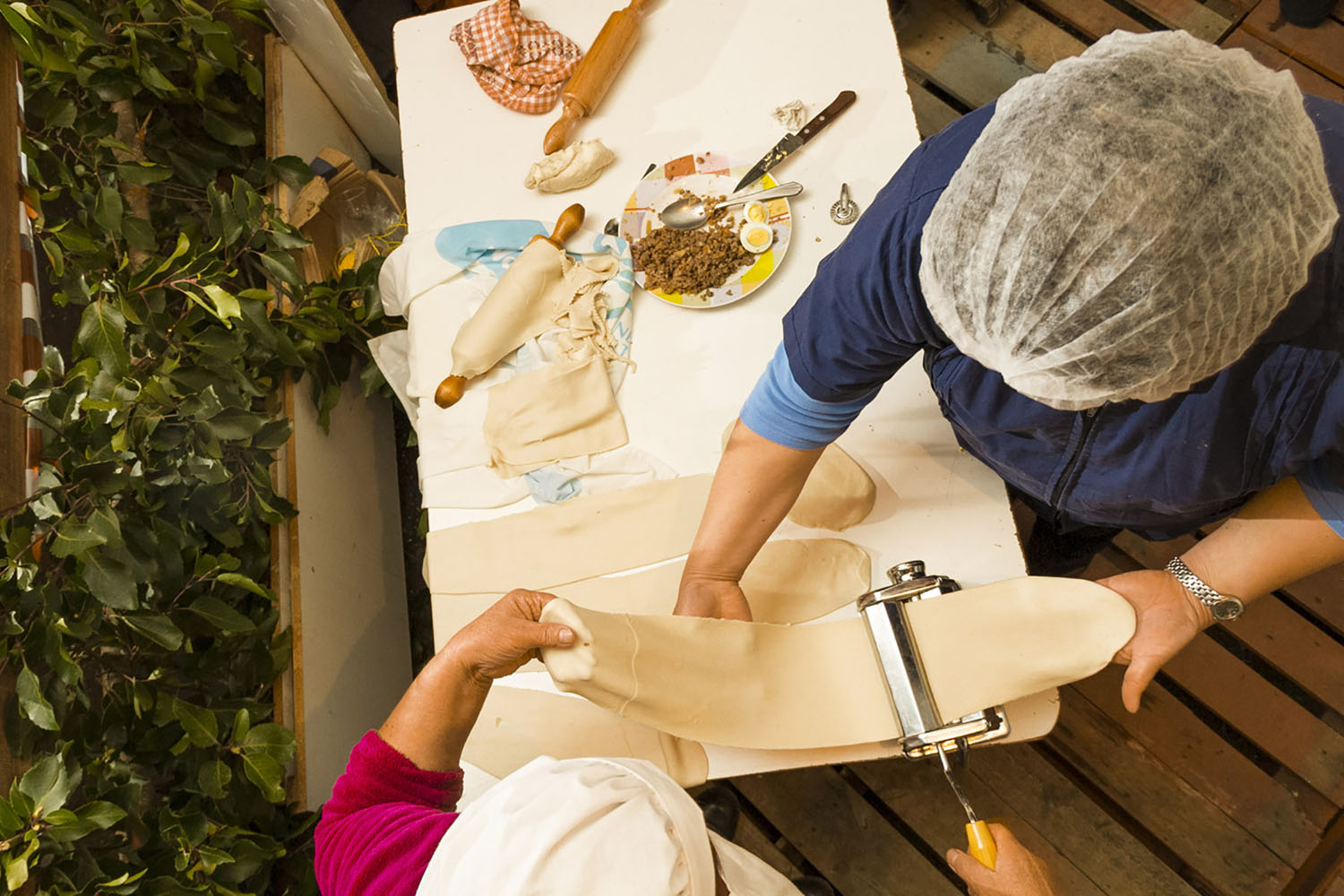 Two women work to craft perfect empanadas