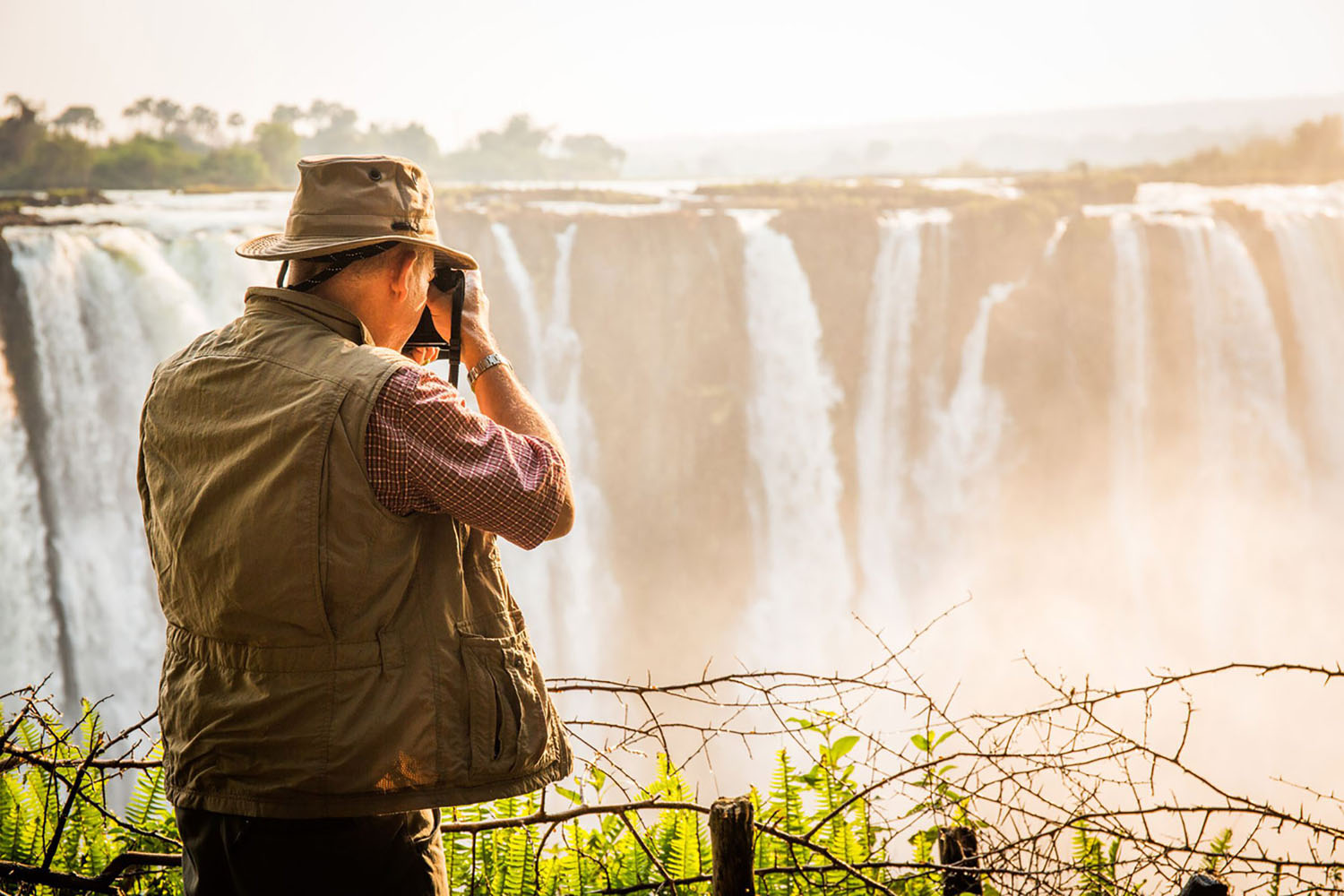 A photographer at sunrise near Victoria Falls