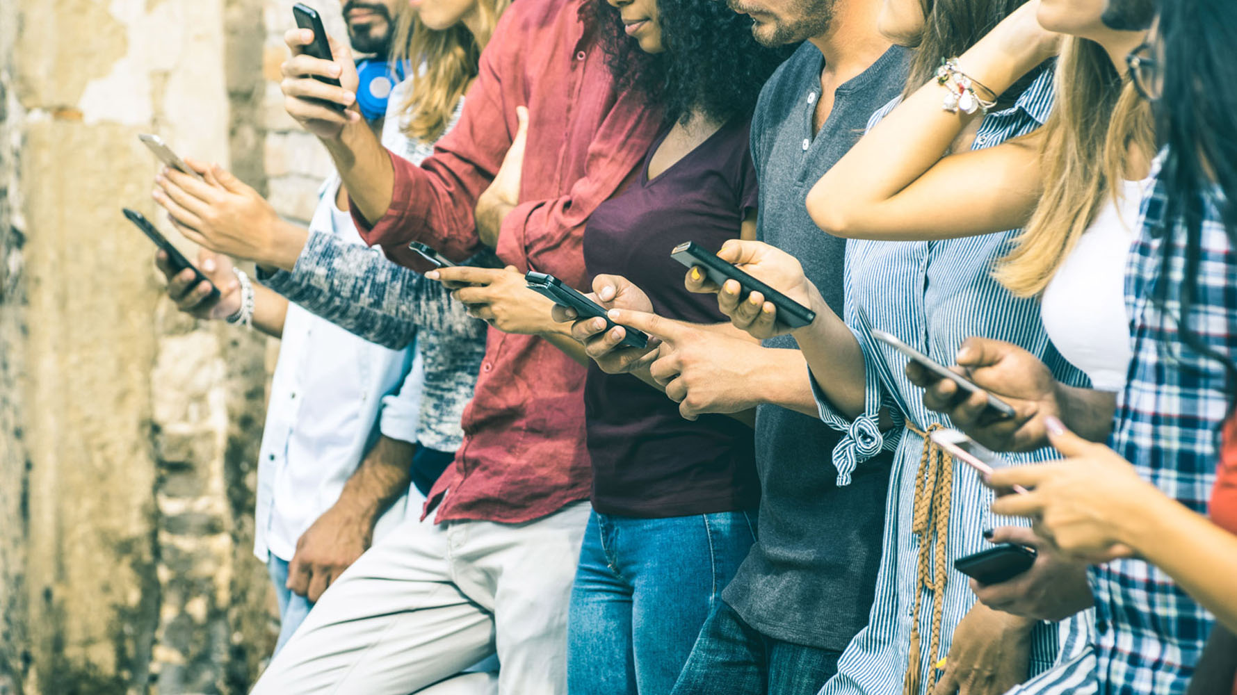 A diverse group of people use their phones to connect to WiFi
