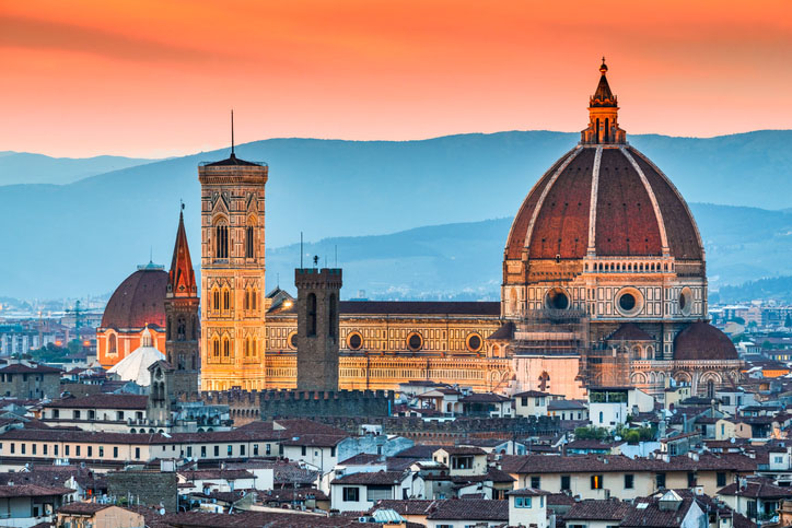 The Florence Cathedral illuminated in the city's skyline at sunset.