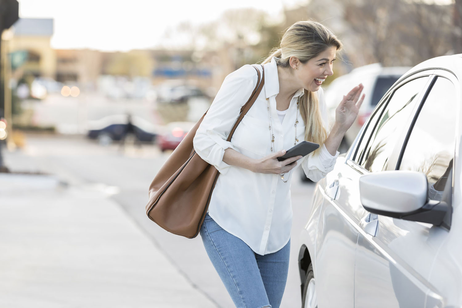 A lady waves at her uber driver