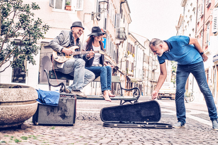 Man listens to performers on a city street