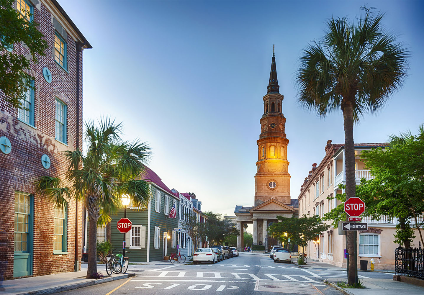 A Charleston ., South Carolina street at twilight with a church in the background