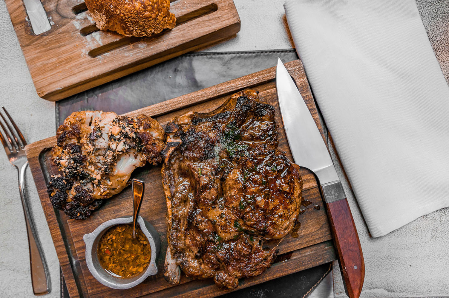 A perfectly cooked steak dinner on a wooden serving tray