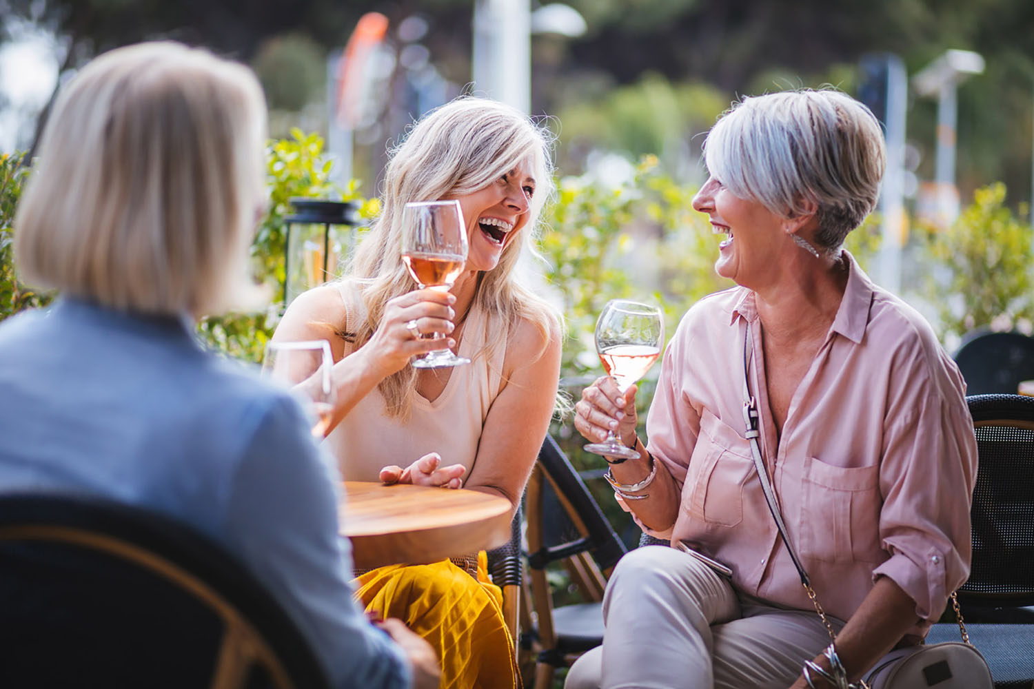 Women drinking wine and laughing at a restaurant