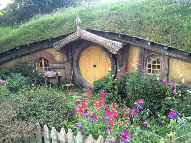 A hobbit house with a yellow door from the hobbiton movie set