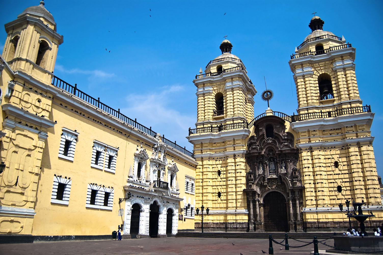 The yellow exterior of the Monasterio de San Francisco in Lima on a sunny day