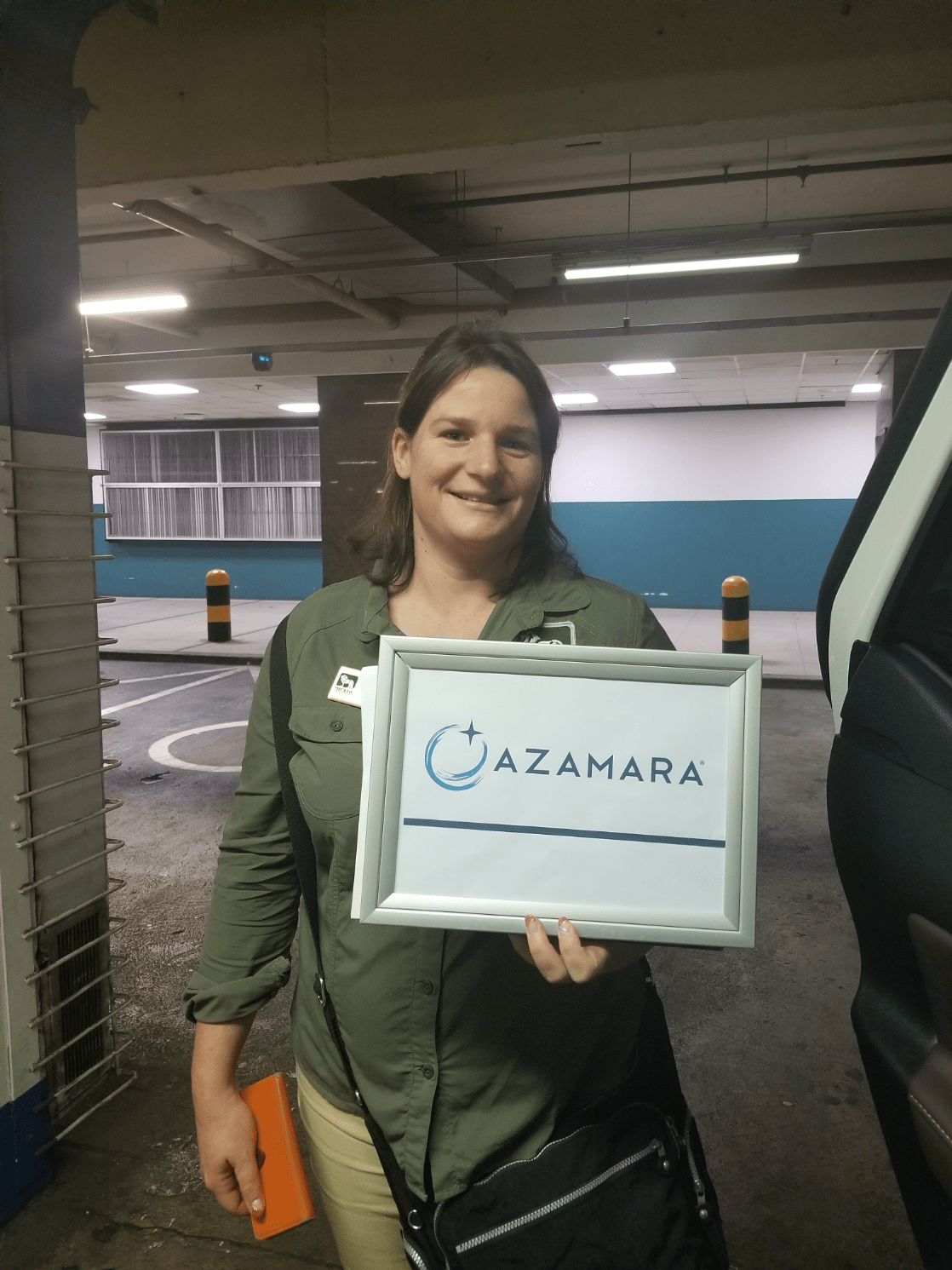 A lady stands holding an Azamara sign